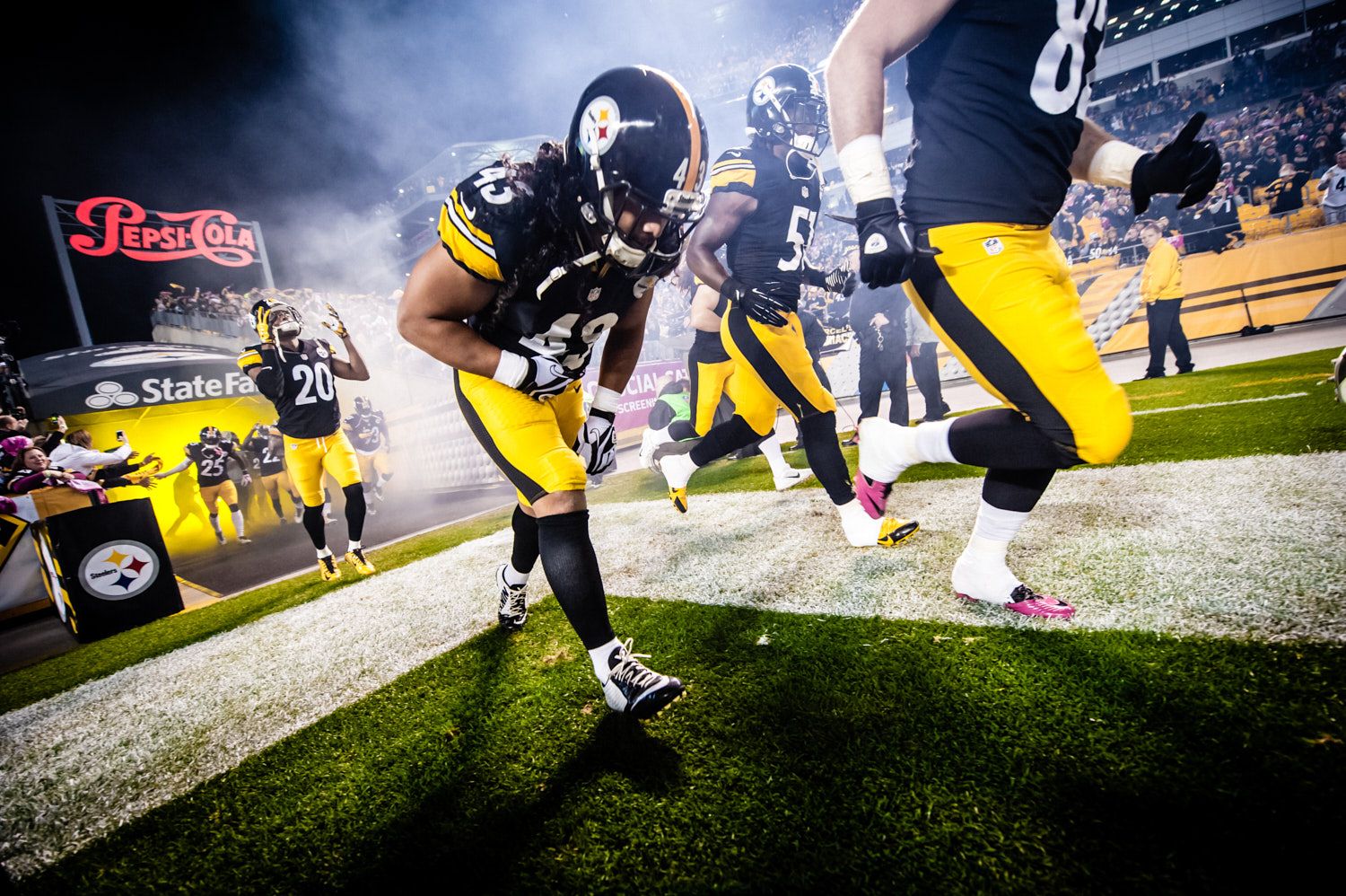 Players charging out of the tunnel through smoke
